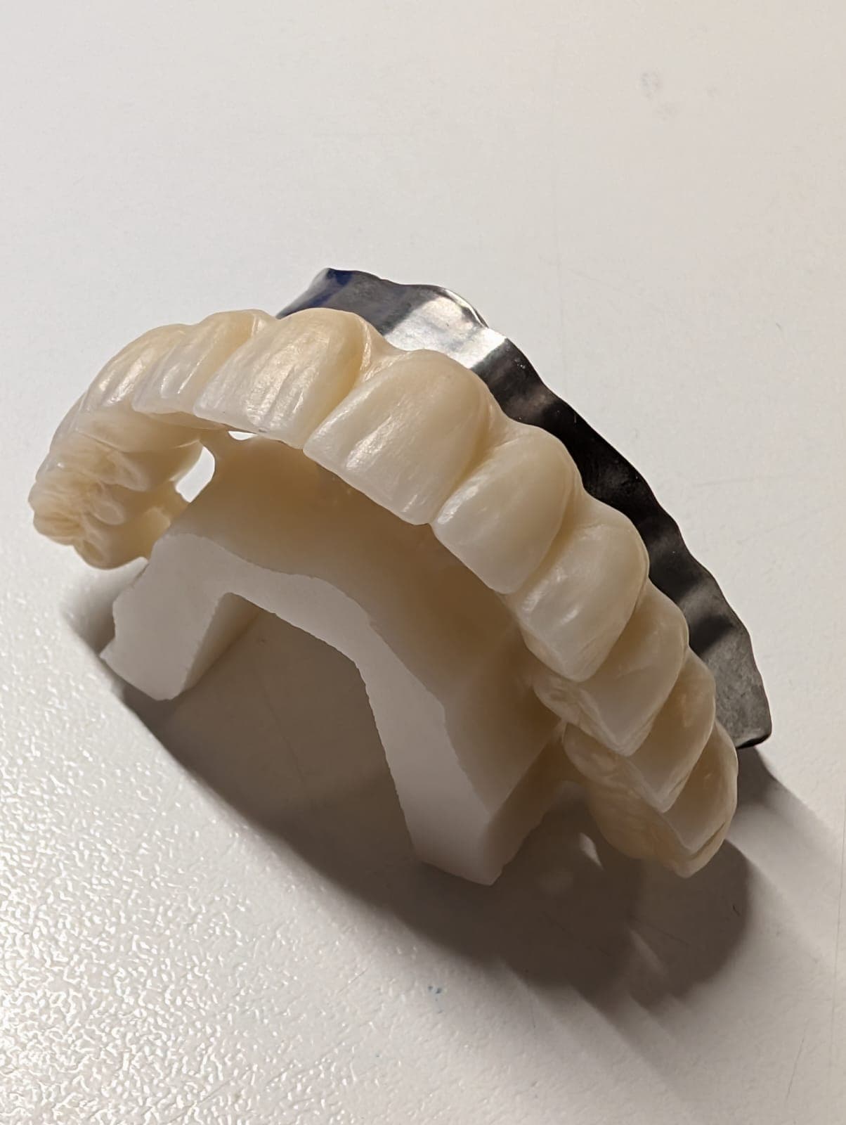 Small titanium implant sub-framework held for inspection